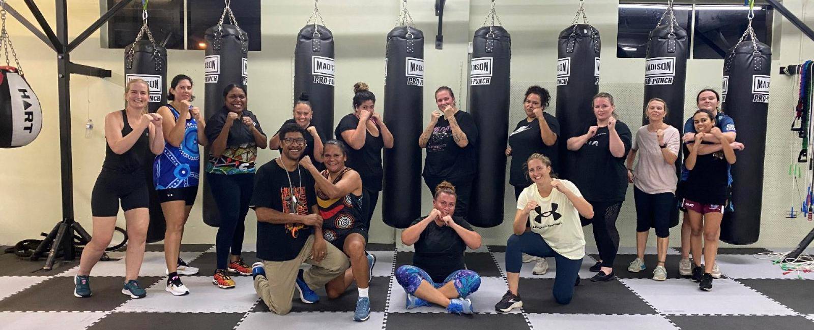 group of boxes posing in front of punching bags